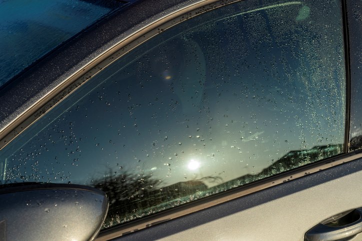 Car window with raindrops reflecting the sun in Portland, OR